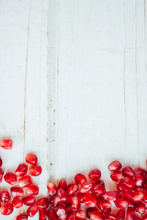 Pomegranate border over white wooden background.の写真素材
