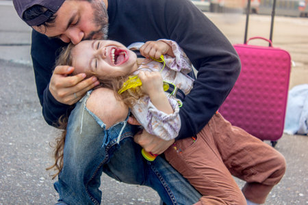 Father and kid playing on railway station, father kissing daughter