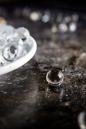 Balls of hydrogel on white plate over black metal backgroundの写真素材
