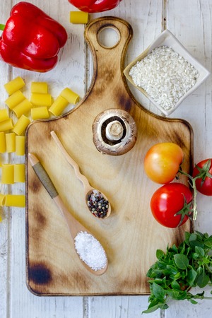 top view of salt and pepper spices in wooden spoons over wooden boardの写真素材