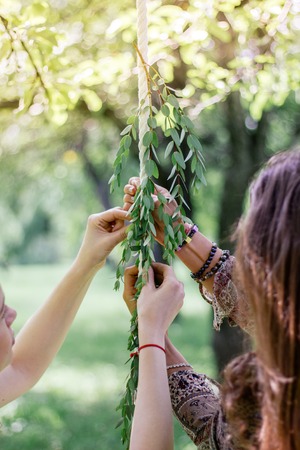 Florist hands with the green branch at park.の写真素材