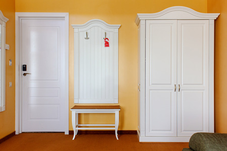 Hotel room with white wardrobe and couch.の写真素材