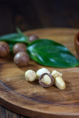 Macadamia nuts on a wooden kitchen boardの写真素材