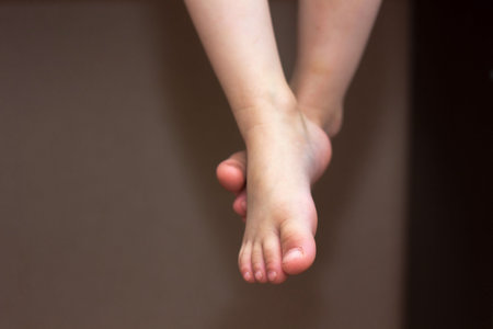 Baby feet. Kid toes while kid sitting on the chair