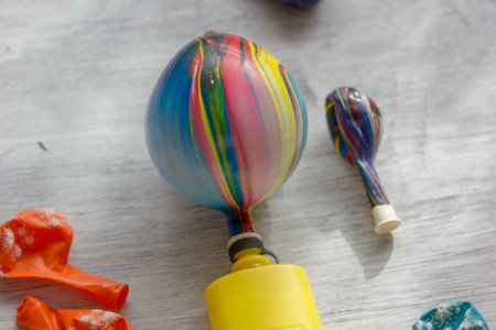 Yellow pump inflating a ballon on white table