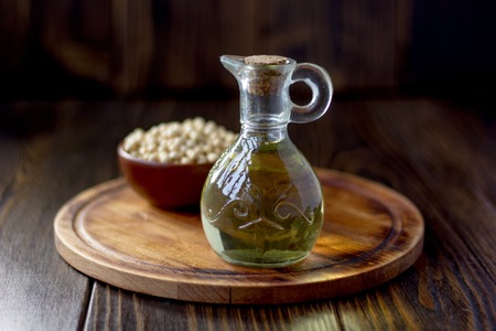 Natural soybean oil in glass bottle with soy beans near itの写真素材
