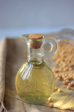 Soy bean oil in glass bottle with soybeans around itの写真素材