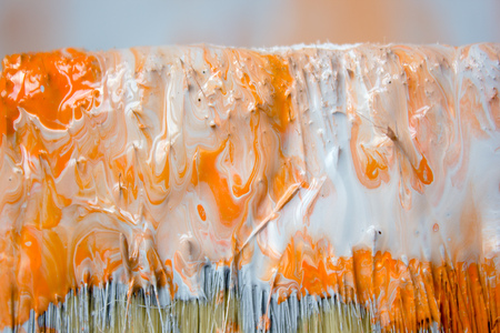 Brush with orange and white paint as renovation and creation.の写真素材