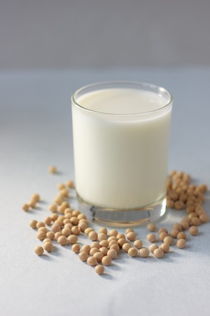 Soybean milk with soy beans around it.の写真素材