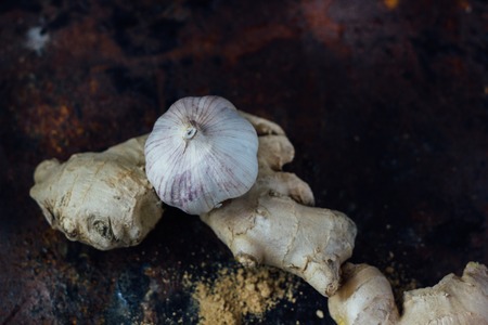 Ginger root and garlic on black rustic surface.の写真素材