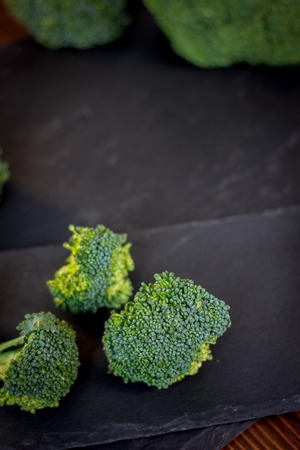 Nice broccoli crowns on a black slate boardの写真素材
