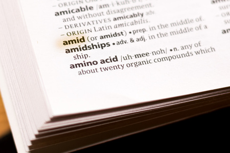 The word or phrase Amid in a dictionary highlighted with marker.の写真素材