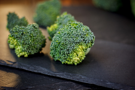 Nice broccoli crowns on a black slate boardの写真素材
