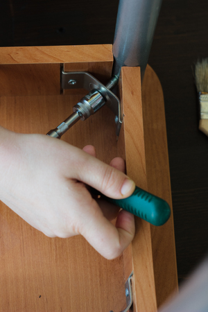 Hands screwing a screw with the socket wrenchの写真素材