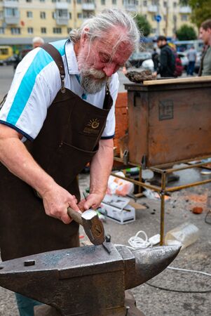 Ryazan, Russia - July 27, 2019: Old blacksmith with hammer on street festival.のeditorial素材