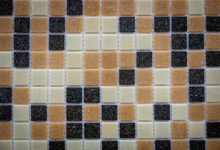 Yellow and dark glass mosaic on the wall as background.
