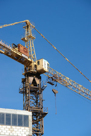 Tower crane on construction site against blue sky.の写真素材