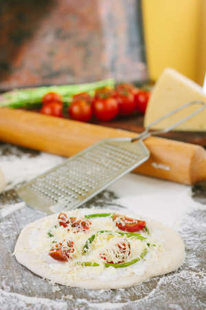 Cooking process of mini pizza with asparagus, tomatoes and cheese.の写真素材