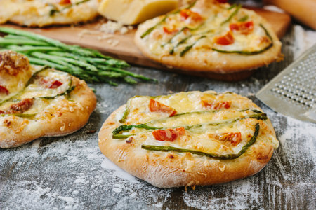 Mini pizza with asparagus. Traditional small pizza for personal eating filling with cheese, tomatoes and asparagus.の写真素材