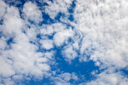 Deep blue sky texture background with white clouds and copy space.の写真素材