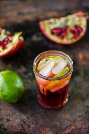 Fresh pomegranate drink - lemonade or cocktail with lime and iceの写真素材