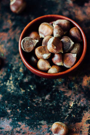 Raw chestnuts in ceramic bowlの写真素材