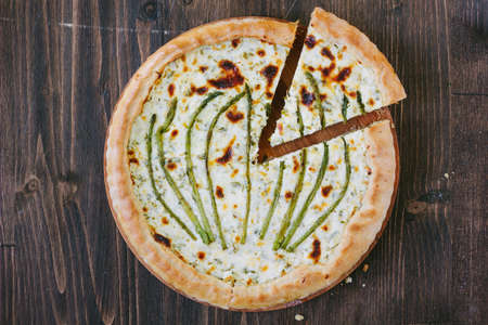 Divided asparagus pie or tart on wooden table.の写真素材