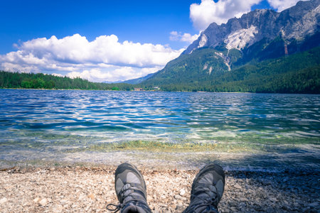 Legs with Hiking Boots on a Lake Beach in Bavaria Germany