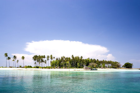 Image of a remote Malaysian tropical island with deep blue skies, crystal clear waters, atap huts...