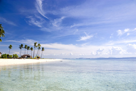 Image of a remote Malaysian tropical island with deep blue skies, crystal clear waters, atap huts...