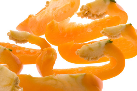 Isolated macro image of a sliced orange coloured capsicum.