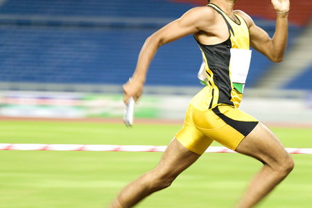 Image of a 4x400 meters athlete in action with some intentional blurring to portray speed.の写真素材