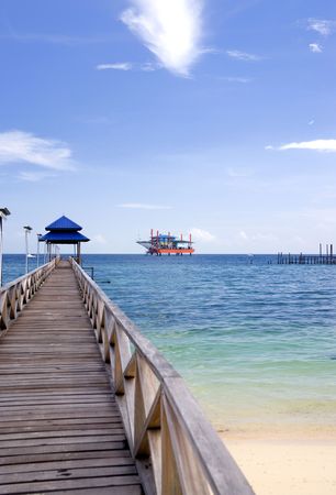 Image of a jetty against a backdrop of a beautiful sea, sky and an oil rig in Malaysia.の写真素材