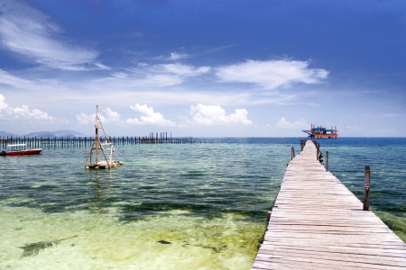Image of a jetty against a backdrop of a beautiful sea, sky and an oil rig in Malaysia.の写真素材