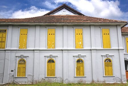 Image of an abandoned old house, now used as a birdhouse. Holes in the windows allow sawllows in to nest. The nest is then collected and processed into the well known Asian Bird Nest Soup, a delicacy in South East Asia.の写真素材