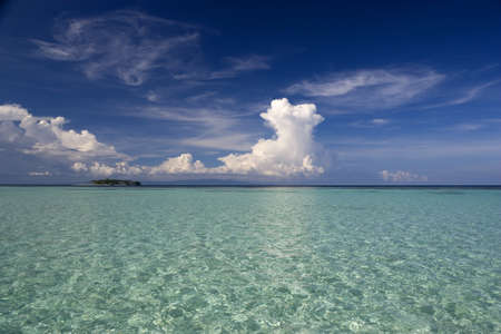Image of the open sea, beautiful formation of clouds, and a small island in Malaysian tropical waters.の写真素材