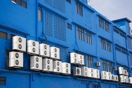 Image of aircondition compressors on a blue building.の写真素材