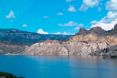rocky mountain formations reflecting in the water under a bright blue skyの写真素材