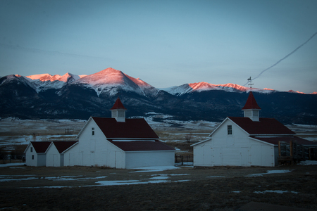 Old ranch buildings with alpen glow at sunriseの写真素材