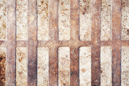 Close-up of Metal Drainage Grate with Industrial Support Beams in Urban Sewer Systemの写真素材