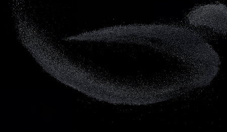 Close-Up of Black Sand Explosion on Dark Background - Fine Sand Particles in Motion