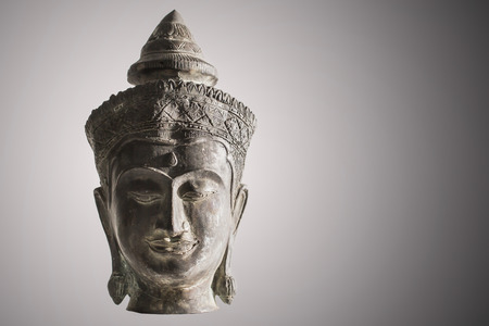 Antique brass buddha sculpture on illuminated black and white backgroundの写真素材