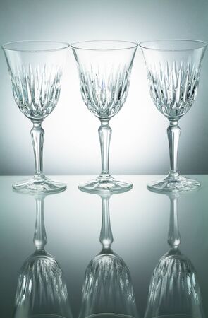 Crystal  glasses with reflection on white illuminated backgroundの写真素材