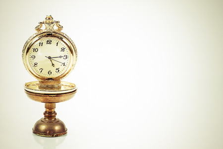 Vintage grunge golden pocket clock on white background in vintage styleの写真素材