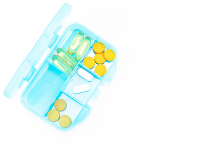 Blue pill box with pills isolated on white background