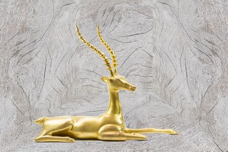 Antique grunge brass deer sculpture on grey vintage wooden backgroundの写真素材