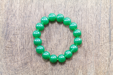 Green round stone  bracelet on vintage grunge wooden backgroundの写真素材