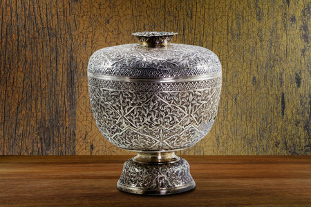 Thai antique ancient grunge silver bowl on wooden tabletop on vintage grunge wooden wall background, still lifeの写真素材