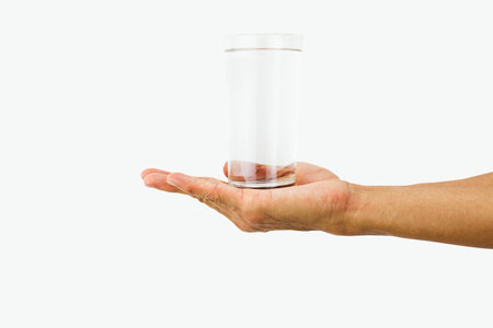 Man hand holding glass of drinking water isolated on white backgroundの写真素材