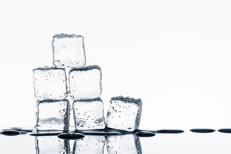 Ice cubes on glossy table on white backgroundの写真素材